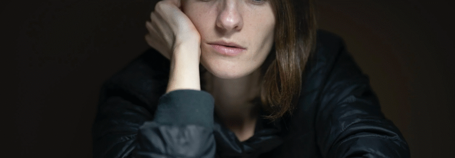 A woman with poor hormonal health looks depressed and tired while seated at a table