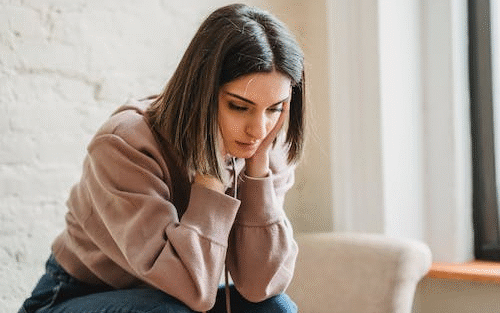 A woman sitting looking tired