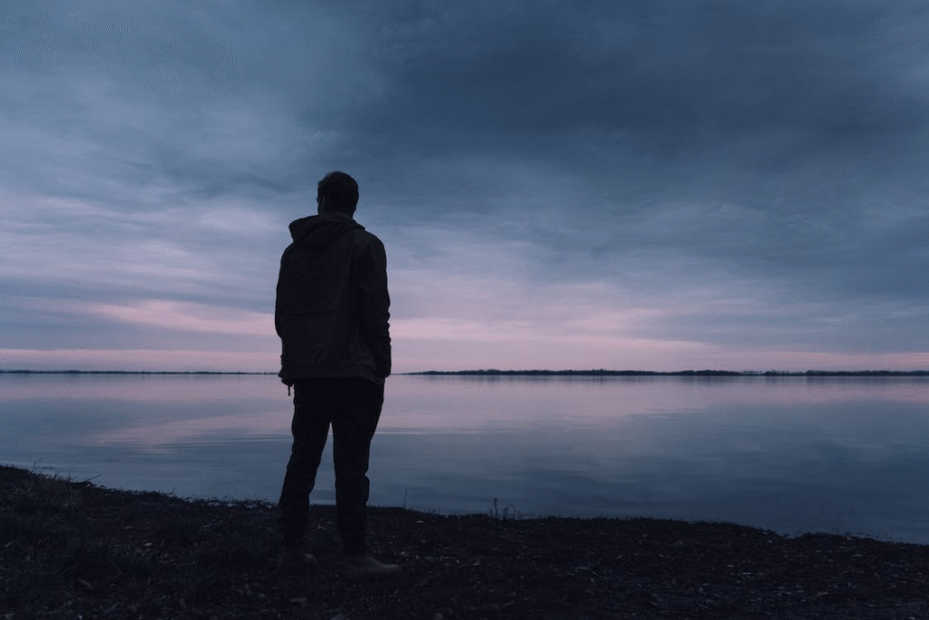 A man standing next to a lake